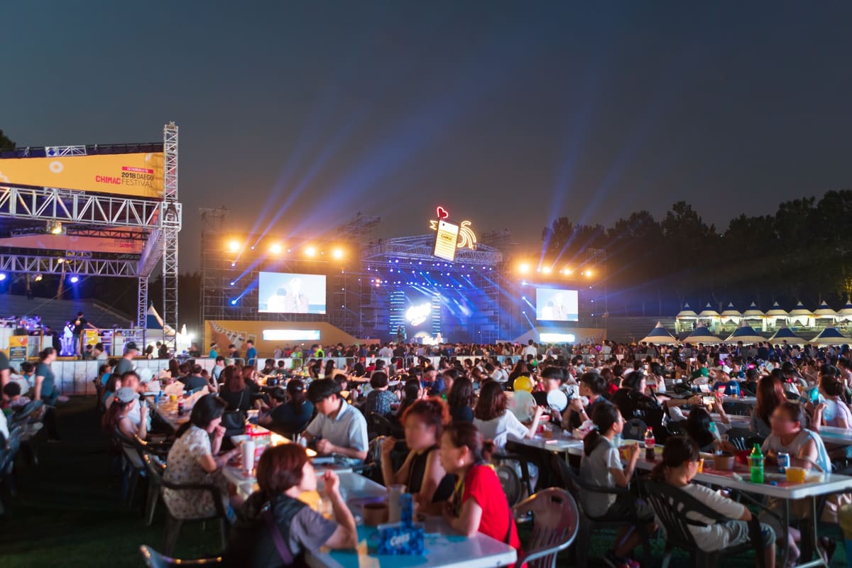 Crowds at tables in front of the main stage at night during the 2018 Daegu Chimac Festival in Duryu Park