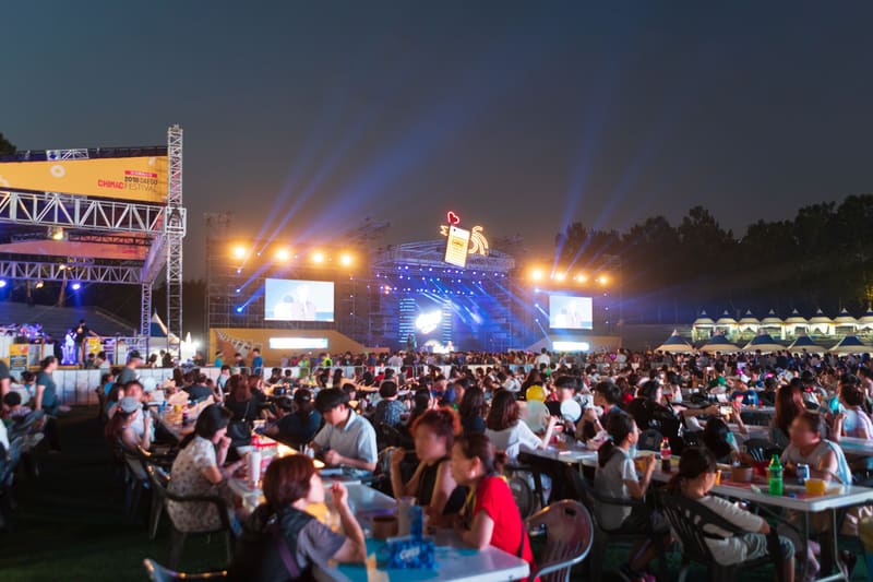 Crowds at tables in front of the main stage at night during the 2018 Daegu Chimac Festival in Duryu Park