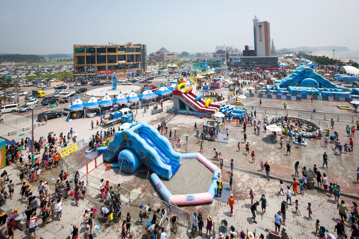 Inflatable mud slides and play pools on the festival square by Daecheon Beach