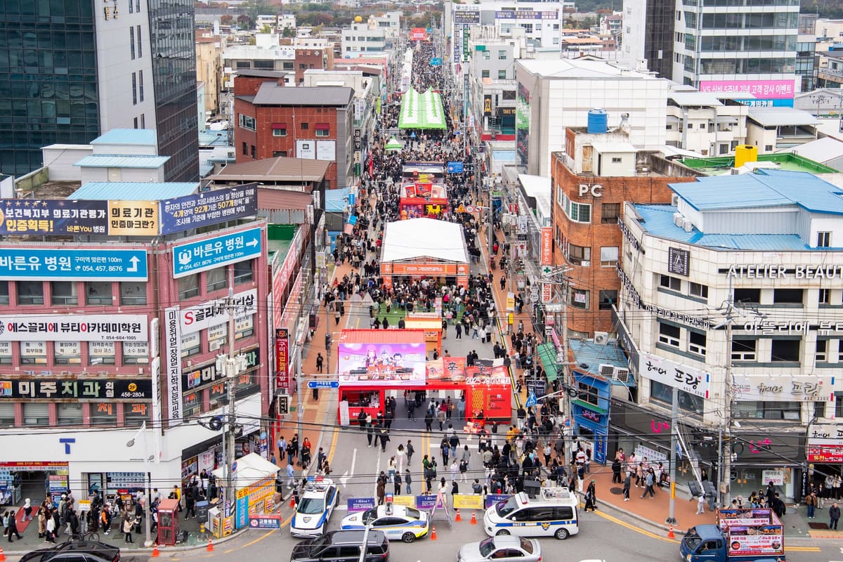 The festival street from above, with booths running between the buildings, 2025