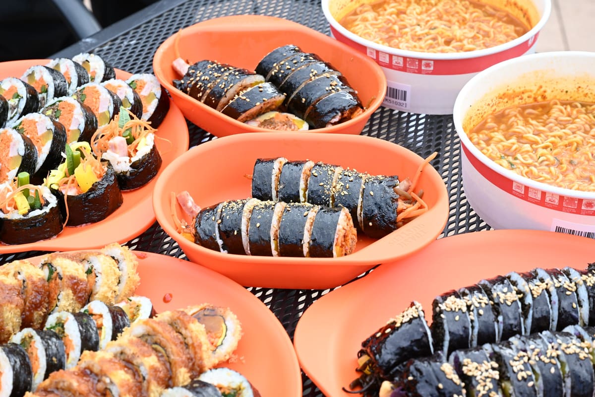 Gimbap of several kinds in festival trays, with cups of ramyeon, at the 2025 Gimcheon Gimbap Festival