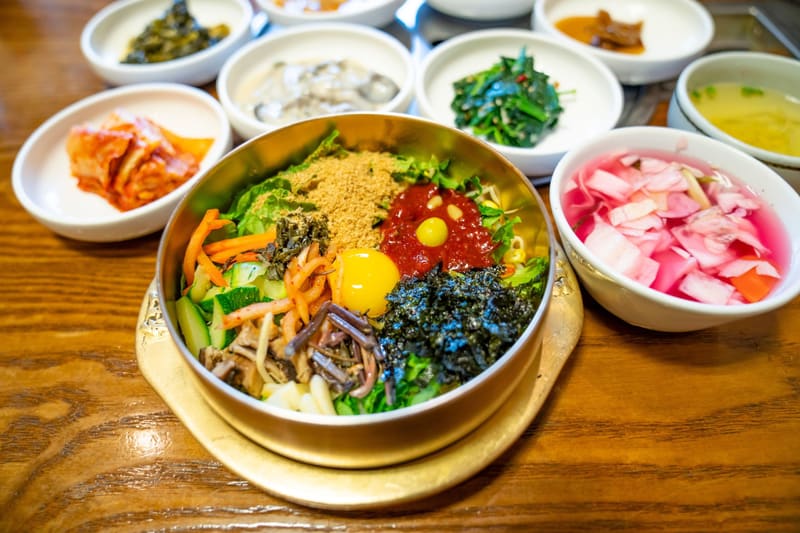 Jeonju bibimbap in a brass bowl with side dishes